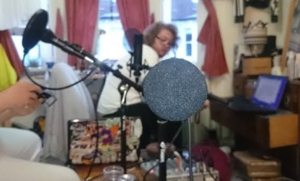 Jack and Niko preparing to record an early episode of Let's Drone Out with a couple of mics and a laptop in Jack's chaotic bedroom.